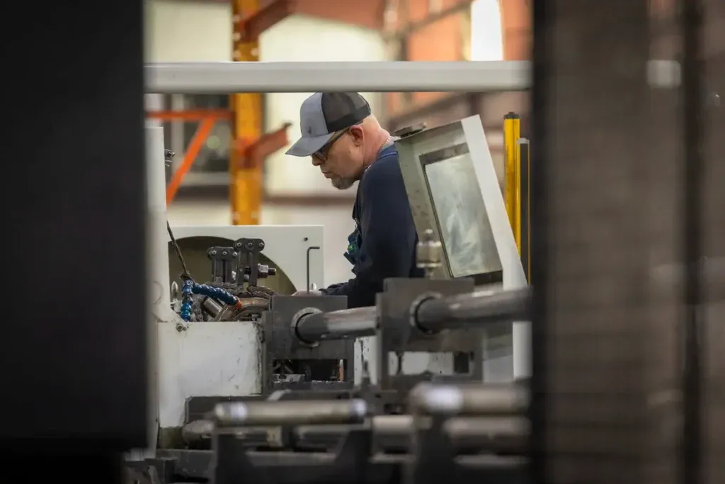 Man repairing cylinder with a machine